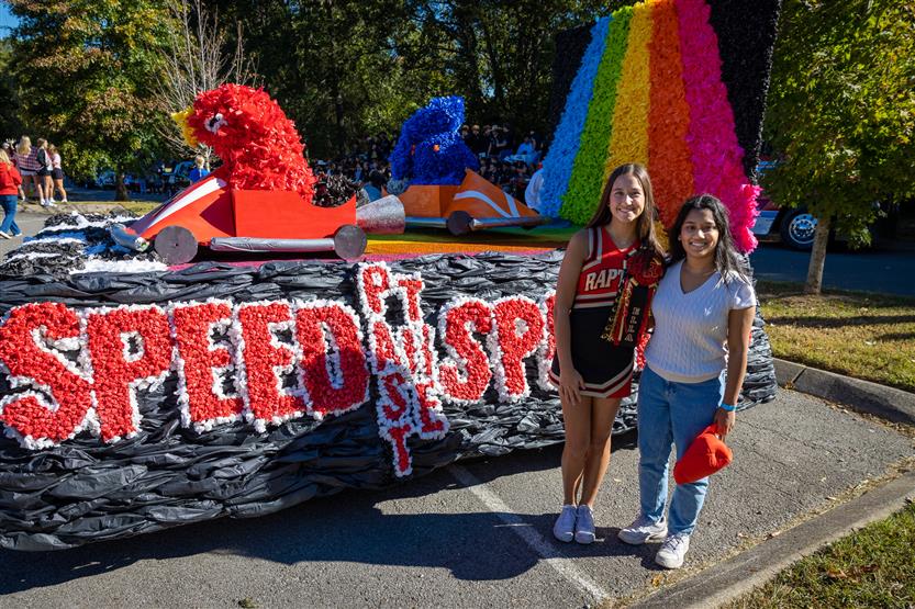 Two students stand in front of a MarioKart float